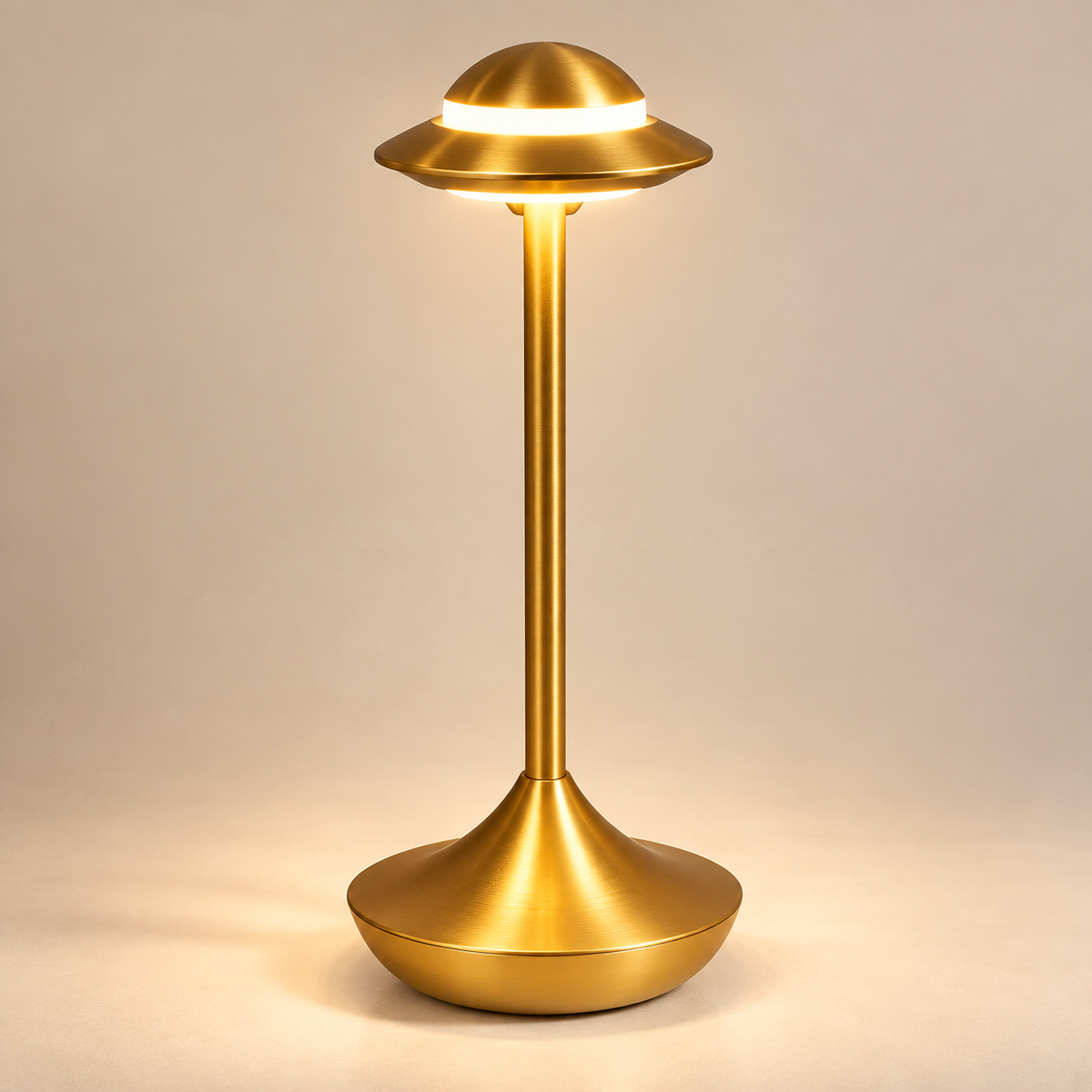 Orbit cordless table lamp in gold, lit with warm light