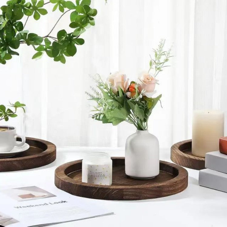 Terra round wooden trays holding a vase and candles
