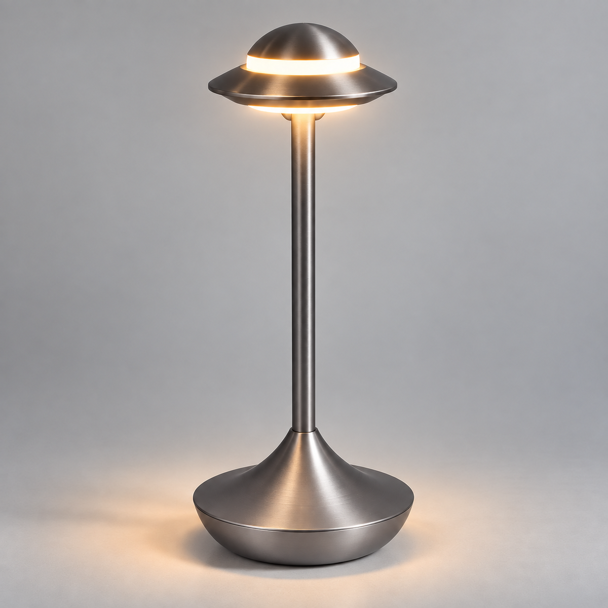 Orbit cordless table lamp in gray, lit with warm light